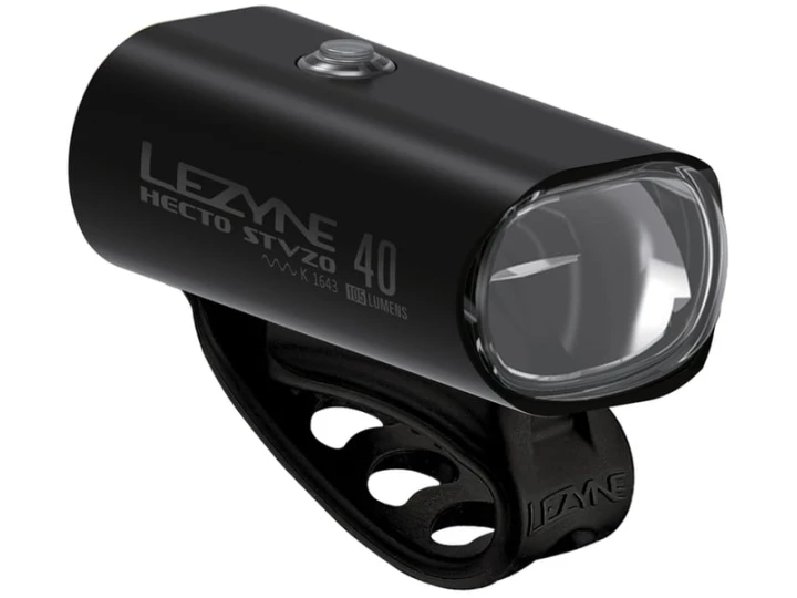 Ein mattschwarzes Lezyne Hecto Drive 40 StVZO-Frontfahrradlicht mit integrierter Gurthalterung, erhältlich in Ihrem bevorzugten E-Bike-Onlineshop. Das kompakte, zylindrische Licht verfügt über eine transparente Linse an der Vorderseite, einen Einschaltknopf oben und einen Markentext an der Seite.