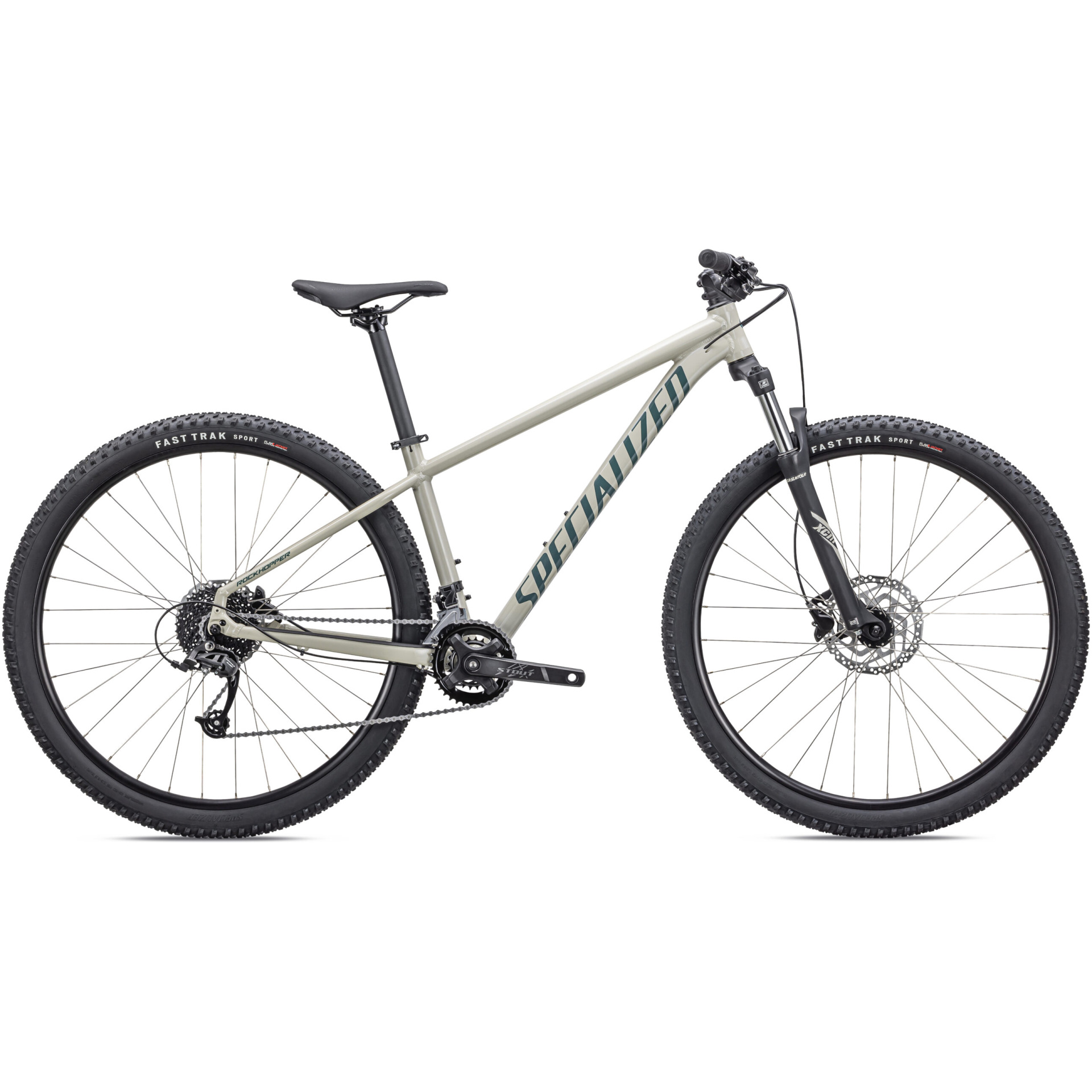 Das Specialized Rockhopper Sport 27.5, ab sofort in unserem Online-Fahrradshop erhältlich, ist ein hellgraues Mountainbike von Lucas Bike mit dem Schriftzug „SPECIALIZED“ in fetten schwarzen Buchstaben auf dem Rahmen. Dieses Hardtail-Design verfügt über eine Vorderradgabel mit Federung und schwarze „FAST TRAK“-Reifen mit dickem Profil. Das Fahrrad ist mit einem einzelnen Kettenblatt vorne und mehreren Gängen hinten ausgestattet.