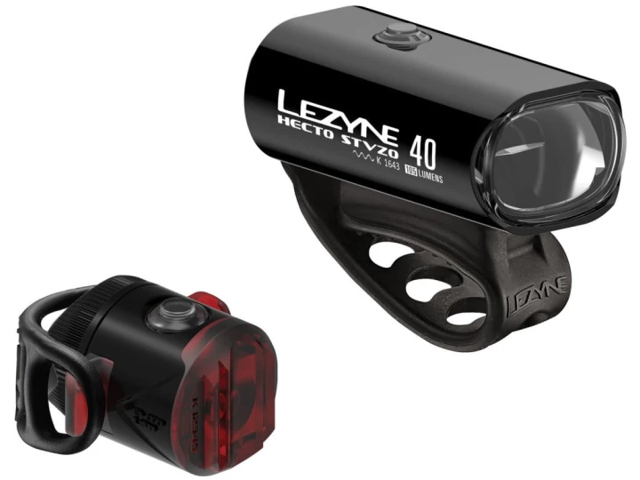 Dieses Bild zeigt das Lezyne Beleuchtungsset Hecto Drive 40;+ Femto, eine ideale Ergänzung für jeden E-Bike-Onlineshop. Das größere Frontlicht rechts mit der Aufschrift „Lezyne Hecto STVZO 40“ zeigt ein schlankes, zylindrisches Design mit einer breiten Linse. Das kleinere Rücklicht links verfügt über eine rote Linse und ein kompaktes Design. Beide Lichter sind auf Gummibändern montiert.