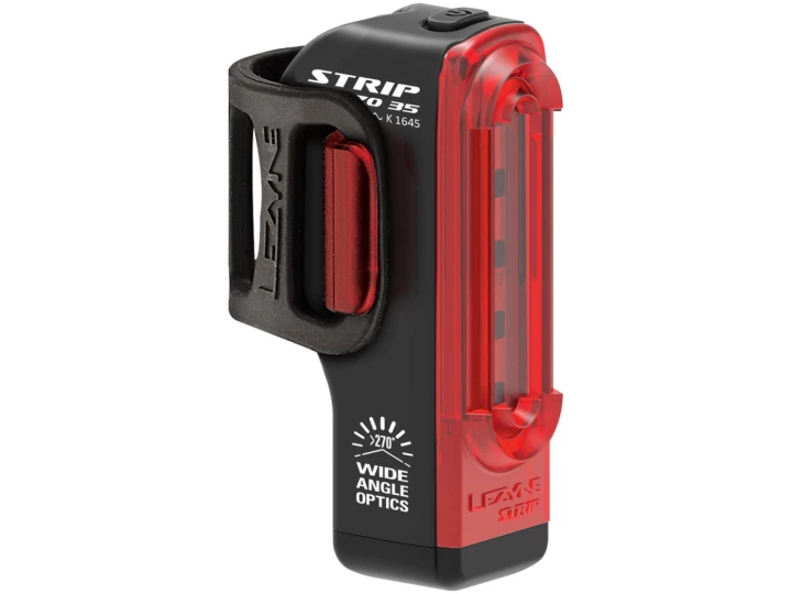 Wir präsentieren das Lezyne Strip Drive StVZO-Fahrradrücklicht mit einem eleganten schwarzen Design und leuchtend roten LED-Leuchten. Dieses Produkt von Lucas Bike bietet Weitwinkeloptik für bessere Sichtbarkeit und lässt sich einfach an einem schwarzen Clip befestigen. Die vertikalen Schlitze zeigen „STRIP 150 35“ und „270° WIDE ANGLE OPTICS“. Jetzt in Ihrem Lieblingsfahrradladen erhältlich!