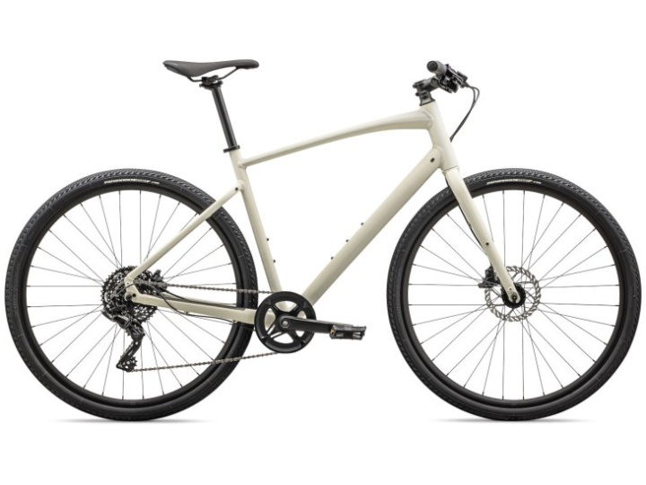 Das Specialized Sirrus X 2.0 ist ein elegantes, mattgraues Hybridfahrrad mit minimalistischem Design. Es verfügt über einen leichten Rahmen, einen flachen Lenker, Scheibenbremsen und ein einzelnes vorderes Kettenblatt mit mehreren hinteren Gängen. Das Fahrrad hat schwarze Reifen und einen schwarzen Sattel und eignet sich daher sowohl für den Stadtverkehr als auch für leichtes Trail-Fahren.