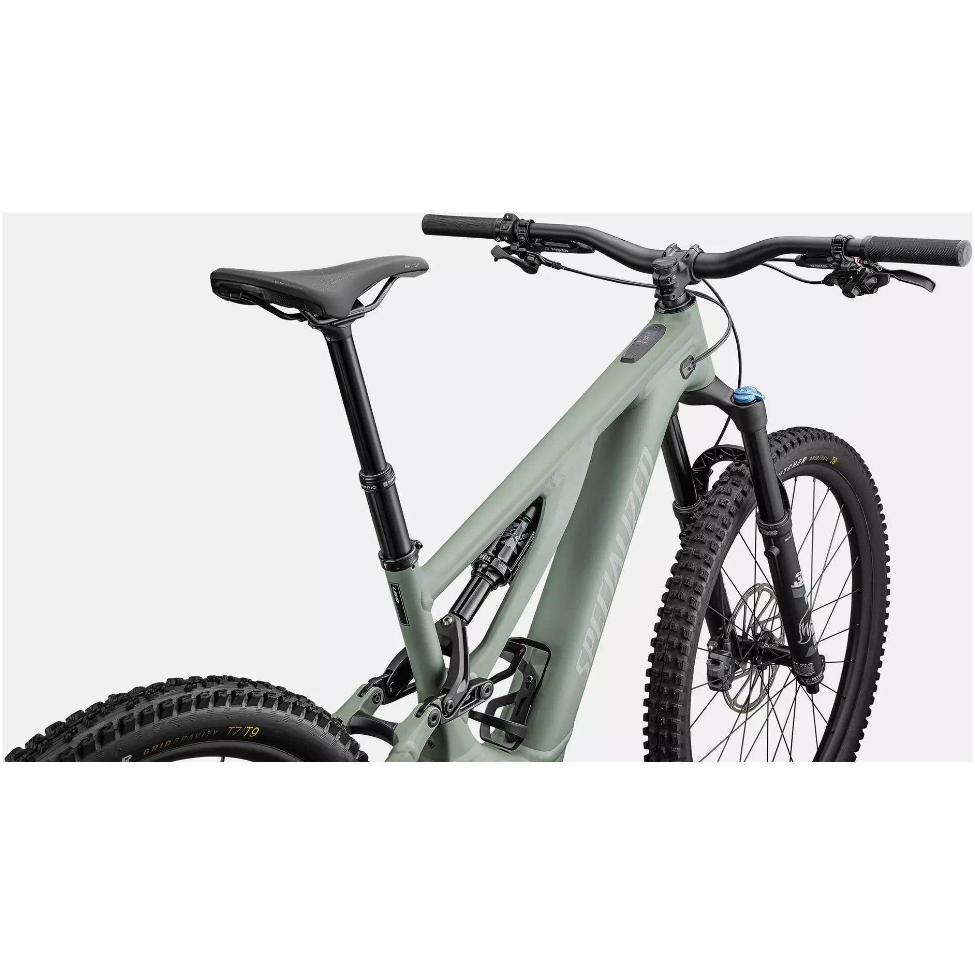 Das Specialized Turbo Levo Comp Alloy ist ein elegantes, modernes Mountainbike mit einem mattgrauen Rahmen, der von hinten zu sehen ist. Es verfügt über breite Reifen mit tiefem Profil, einen gebogenen Sattel und ein Hochleistungsfederungssystem. Das Fahrrad hat einen schwarzen Lenker und zeichnet sich durch ein stromlinienförmiges Design aus, das für Offroad-Strecken geeignet ist.