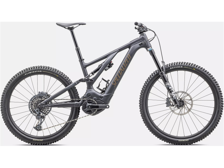 Ein elegantes schwarzes Mountainbike mit großen Reifen, einem robusten Rahmen und einem vollgefederten System. Das Specialized Turbo Levo Comp Alloy trägt den Markennamen „Specialized“ in einem goldenen Farbton auf dem Rahmen. Es verfügt über Scheibenbremsen und einen ausgeklügelten Getriebemechanismus, der für das Radfahren im Gelände entwickelt wurde.