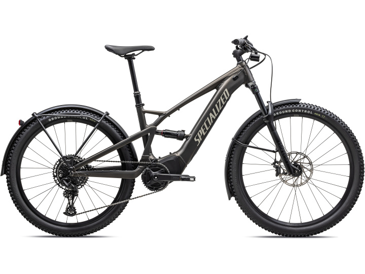 Ein schwarzes Specialized Turbo Tero X 4.0 Elektro-Mountainbike mit Vorderradfederung, Scheibenbremsen, Stollenreifen und dem Markennamen in großen Buchstaben auf dem Rahmen, von der Seite auf weißem Hintergrund fotografiert.