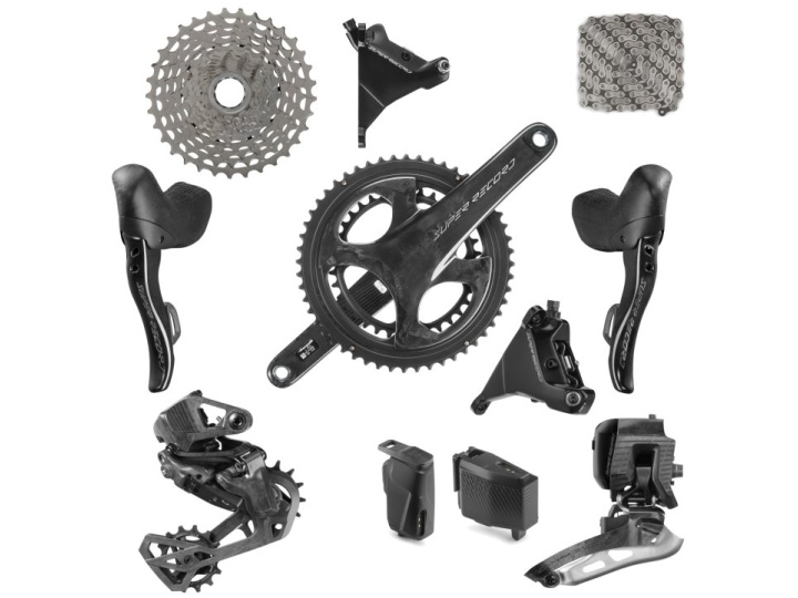 Die Schaltgruppe Campagnolo Super Record WRL 13s mit schwarzen Antriebskomponenten wie Kettenradgarnitur, Kassette, Schalthebel, Umwerfer, Kette und elektronischen Bauteilen ist symmetrisch auf weißem Hintergrund dargestellt.