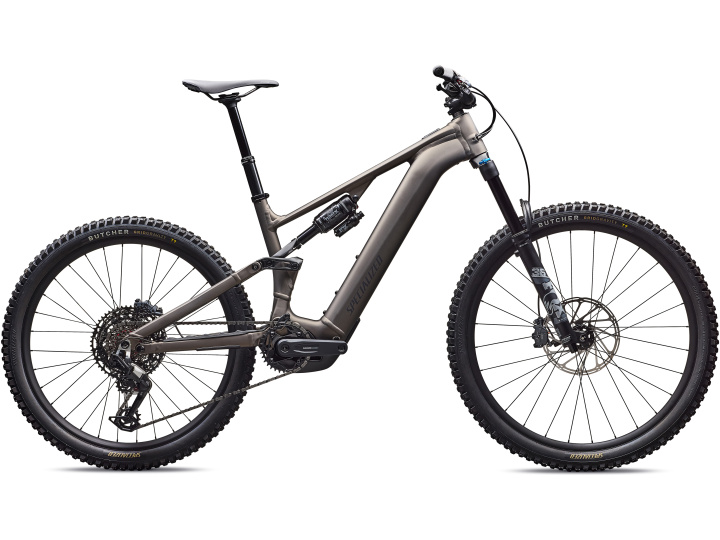 Das Specialized Turbo Levo 4 Comp Alloy ist ein modernes Elektro-Mountainbike mit mattgrauem Rahmen, dicken Stollenreifen, Federung vorne und hinten und Scheibenbremsen, im Seitenprofil auf weißem Hintergrund.