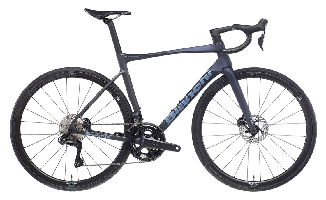 Das Bianchi Specialissima Comp 105 DI2 ist ein schlankes, modernes Rennrad mit tiefem Lenker, dünnen Reifen, einem leichten schwarz-blauen Rahmen, Scheibenbremsen und aerodynamischen Eigenschaften.