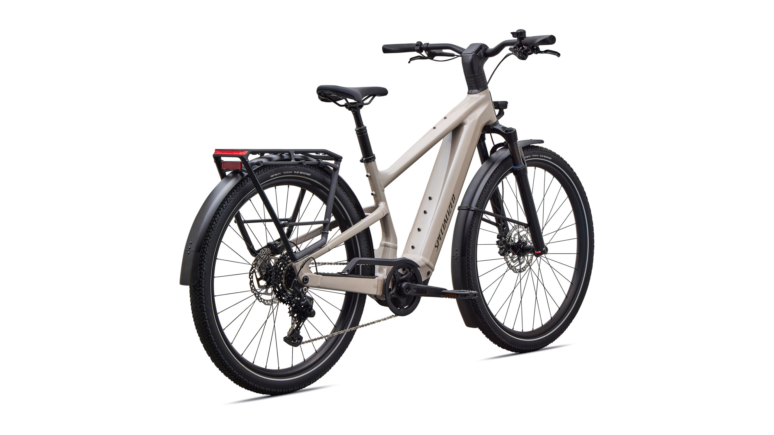 Das Specialized Turbo Vado 3 4.0, hier in Beige mit schwarzen Laufrädern und Komponenten abgebildet, ist von hinten links zu sehen. Es verfügt über einen Gepäckträger am Heck, Scheibenbremsen sowie vordere und hintere Schutzbleche, die sich alle vor einem weißen Hintergrund abheben.